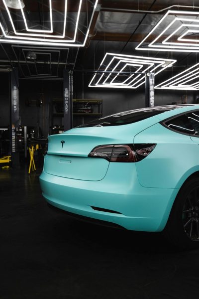 teal colored tesla with tinted windows